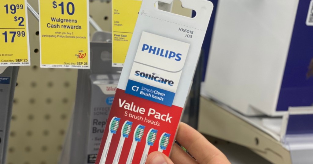 hand holding white package of toothbrush heads