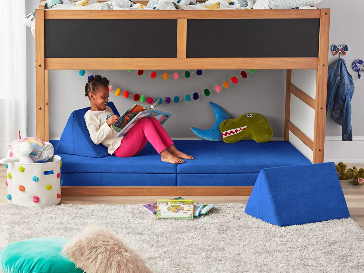little girl sitting on blue colored kids sized couch
