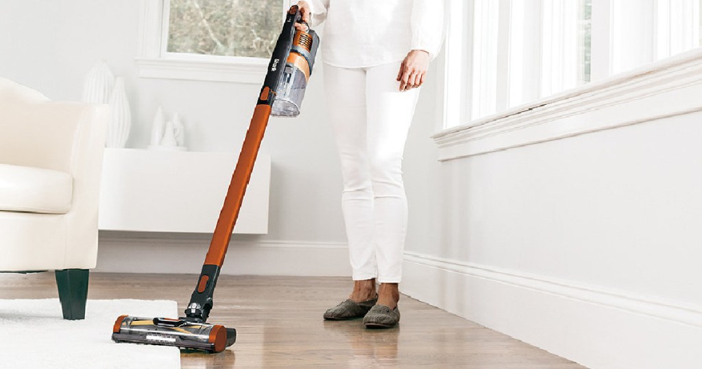 woman vacuuming with orange vacuum