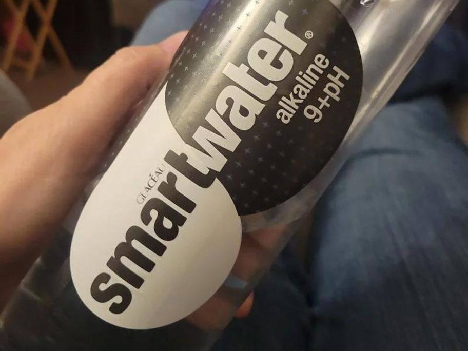 A hand holding a Smartwater alkaline with antioxidant bottle 