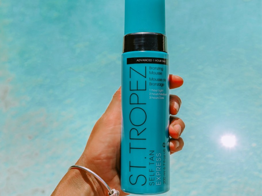 hand holding a bottle St. Tropez Self Tan Express Bronzing Mousse