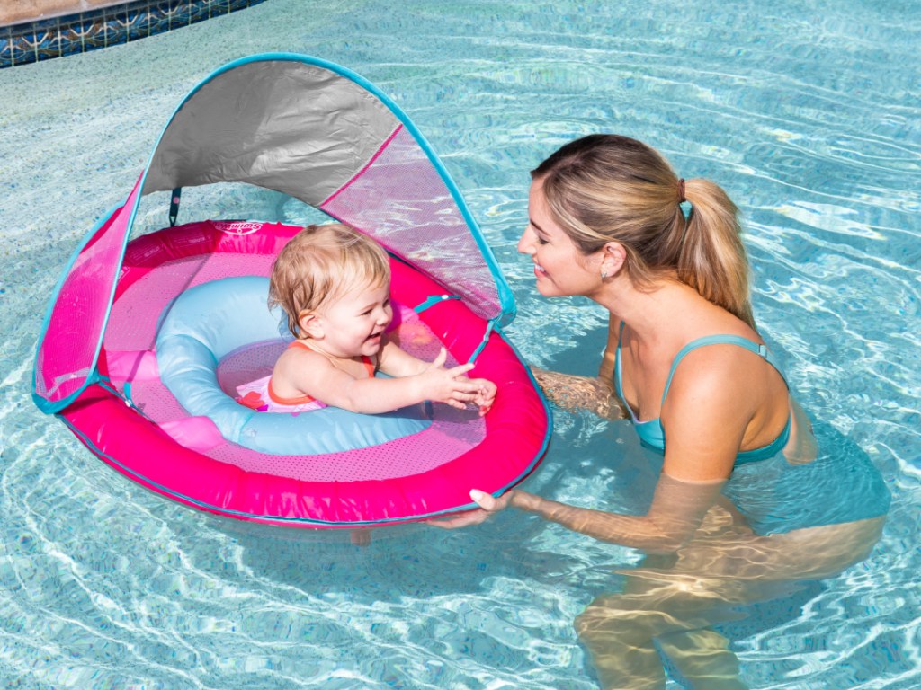woman in pool with baby in inflatable chair float
