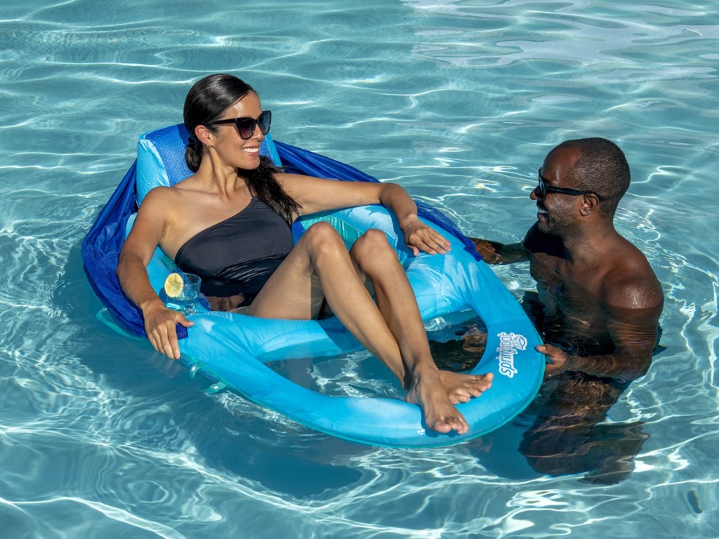 man standing in pool and woman sitting in inflatable chair float