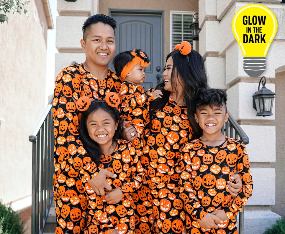 family in matching pumpkin pajamas