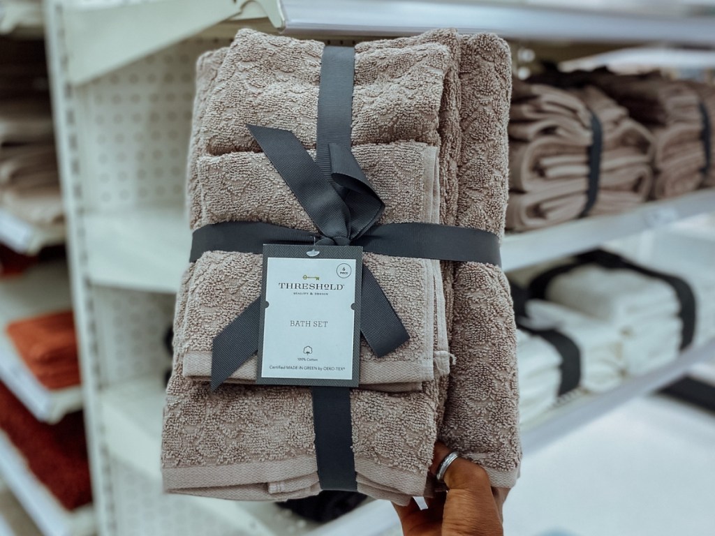 hand holding brown threshold bath towel set in store
