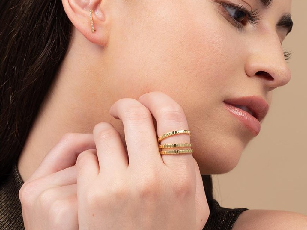 woman wearing a 3-piece gold tone ring set 
