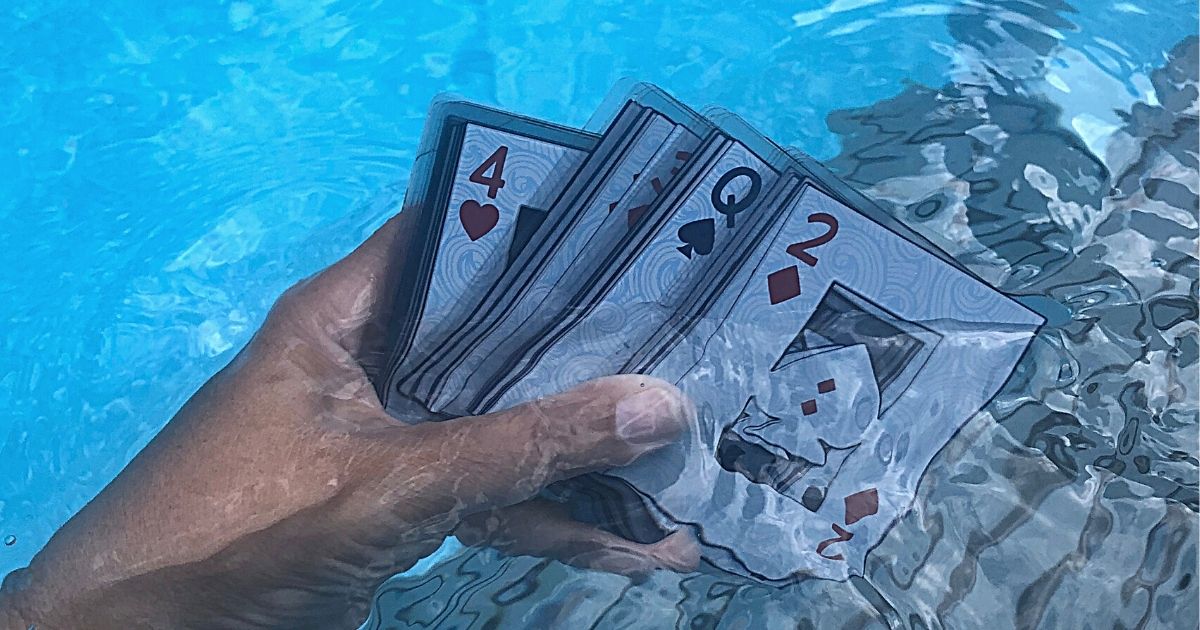hand holding waterproof playing cards under water