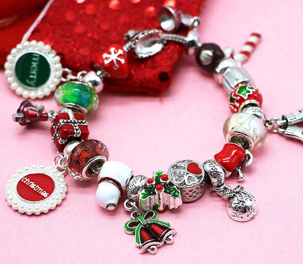 close up of christmas charm bracelet on pink table