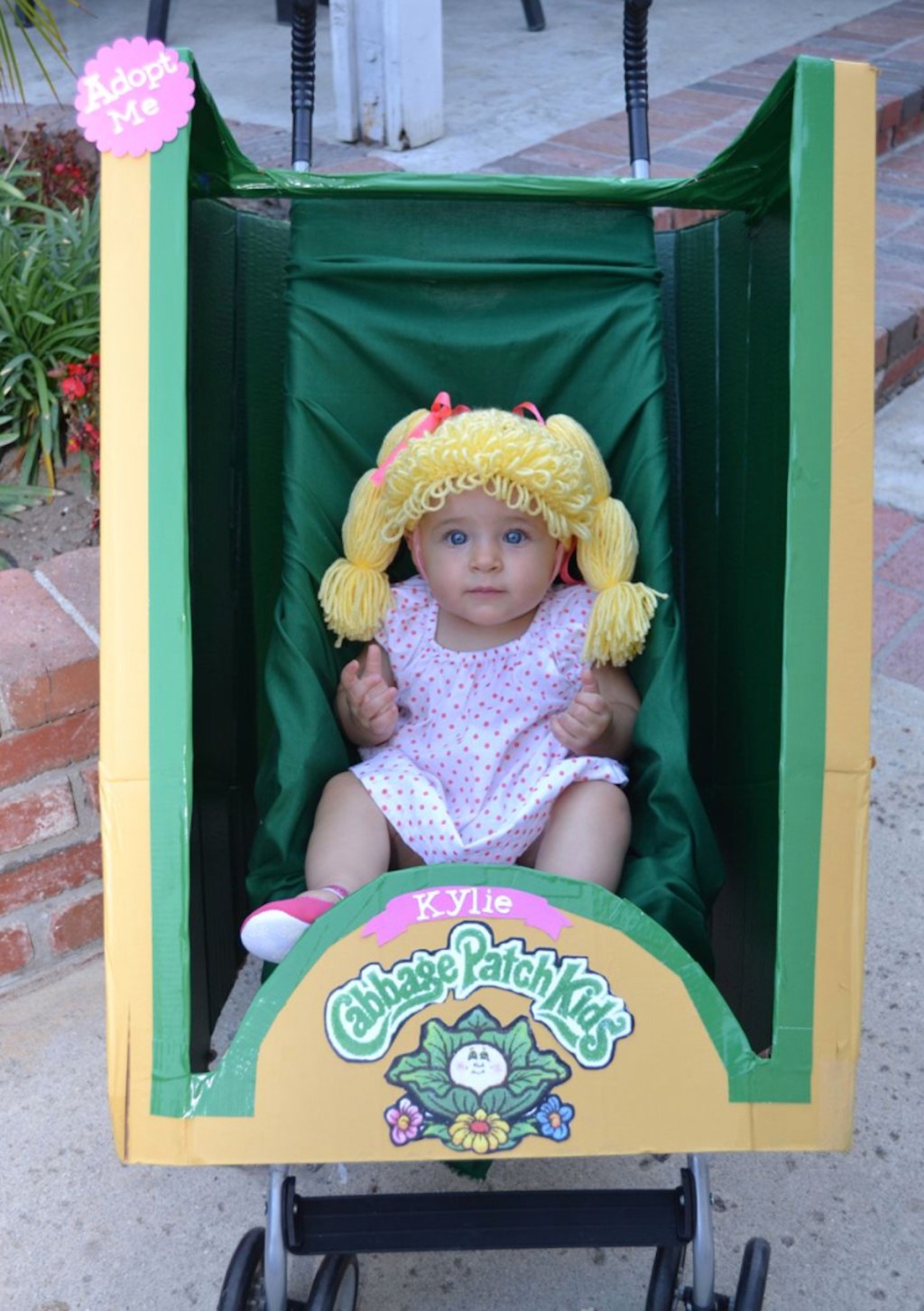 baby sitting in stroller with cabbage patch kids costume on