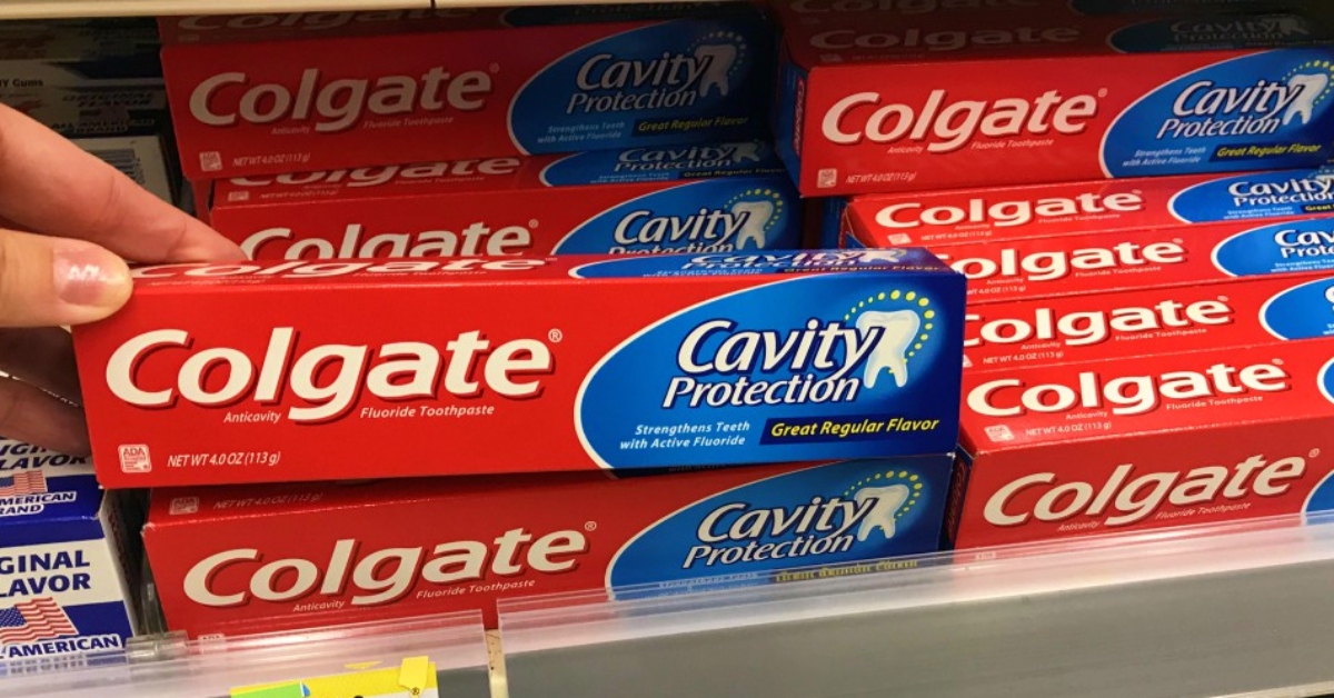 lifting Colgate toothpaste from store shelf