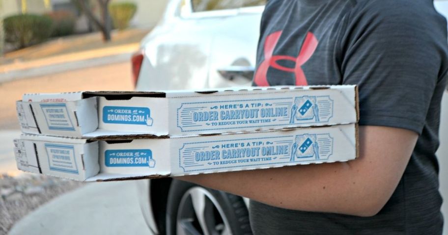 person carrying boxes of Domino's pizza