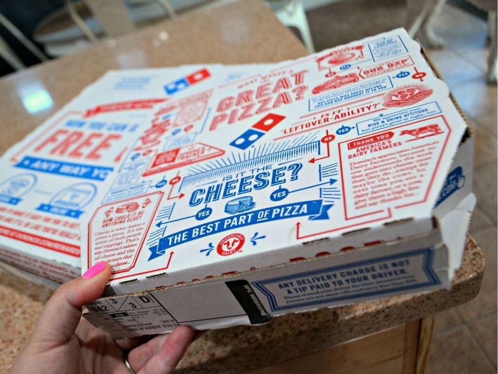 Hand holding a Domino's pizza box
