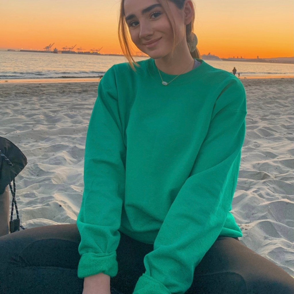 woman wearing green sweatshirt on beach
