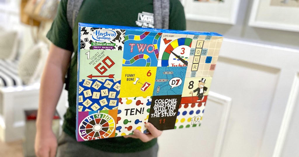 boy holding sock advent calendar with photos of classic board games