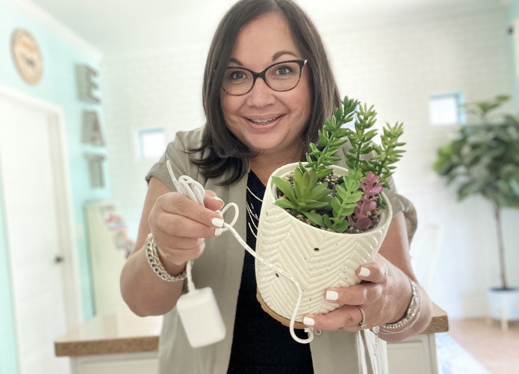 woman holding succulent planter with cord