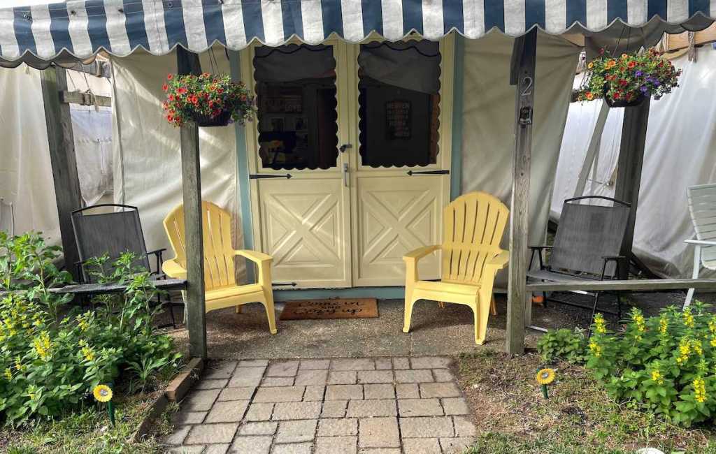 white tent porch with yellow chairs and plants