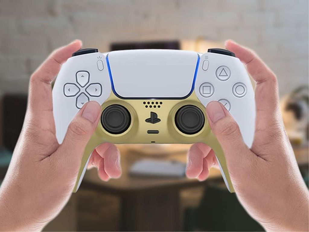 hand holding onto gold and white gaming controller