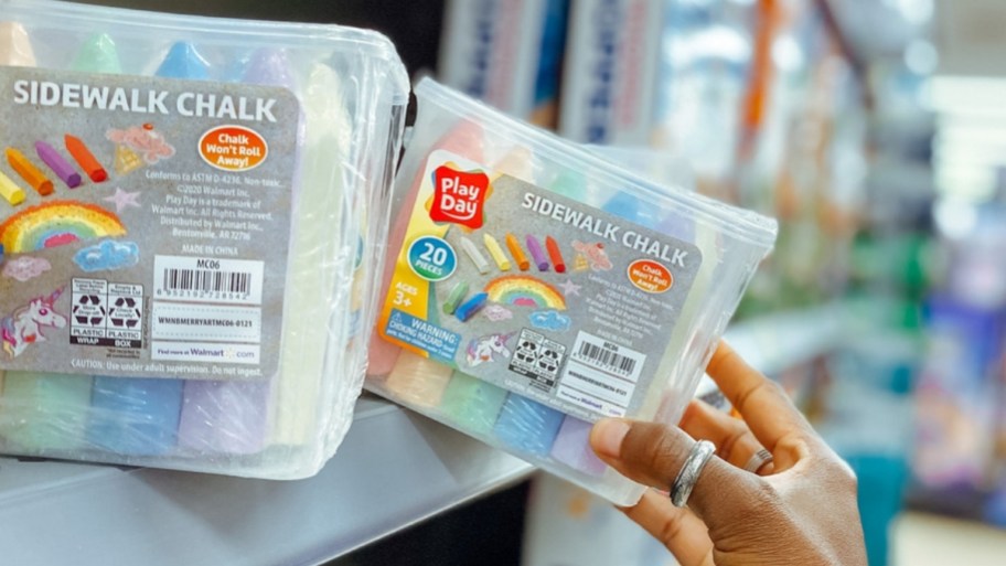 womans hand reaching for a package of sidewalk chalk