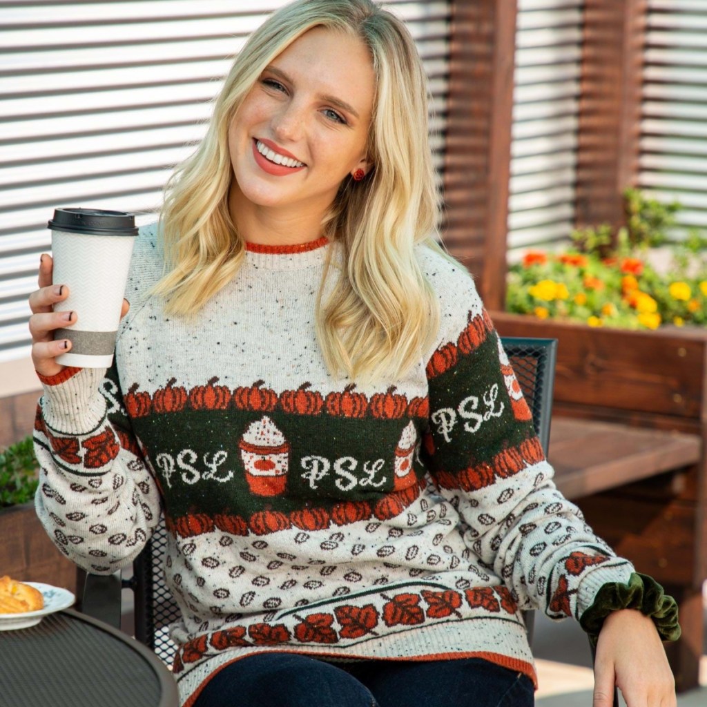 woman holding coffee and wearing PSL sweater