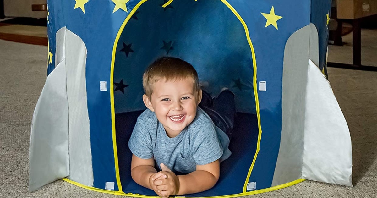 young boy inside a rocket ship tent