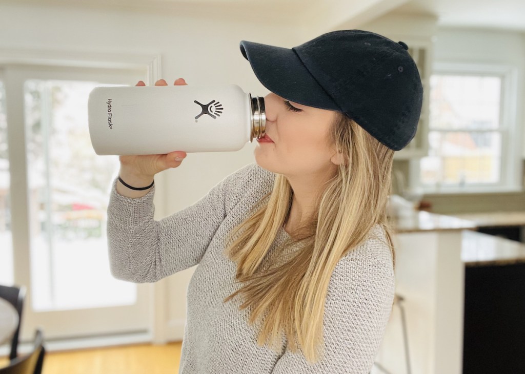 woman drinking out of white hydro flask