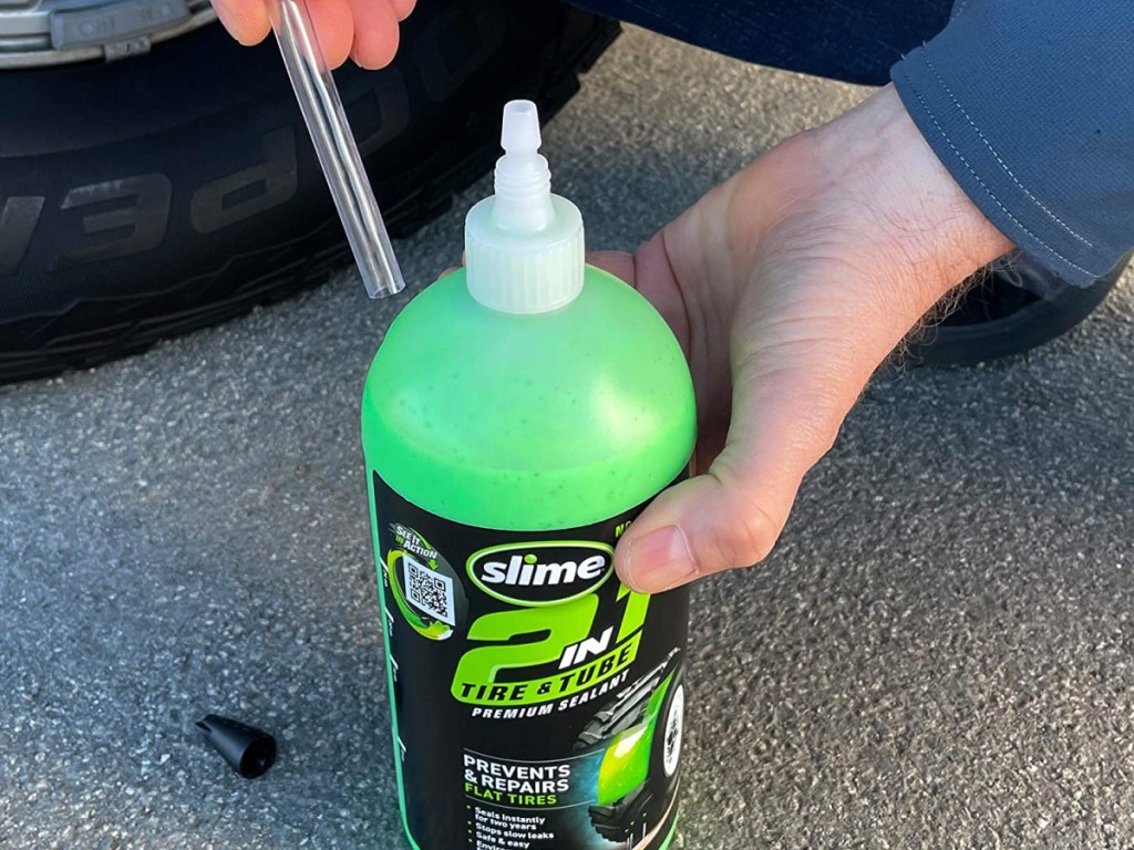 man holding slime tire sealant bottle