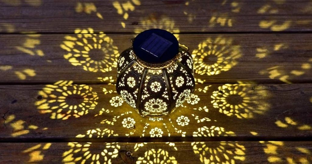 solar lantern lit up at night showing light patterns on deck floor