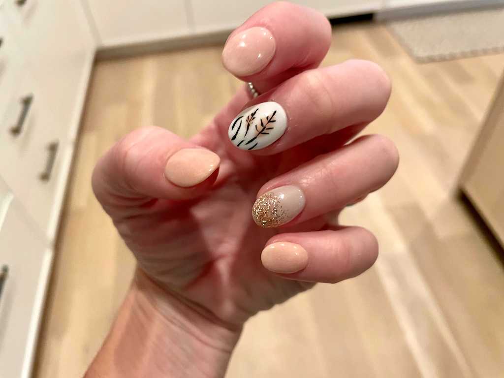 woman showing off fall nail art design manicure 