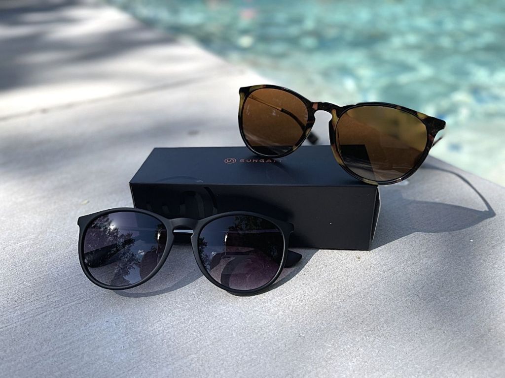 two pairs of sungait sunglasses by pool