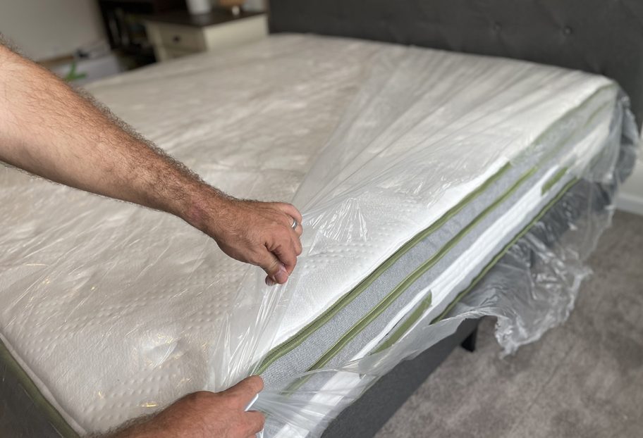 hands taking plastic off new novilla mattress