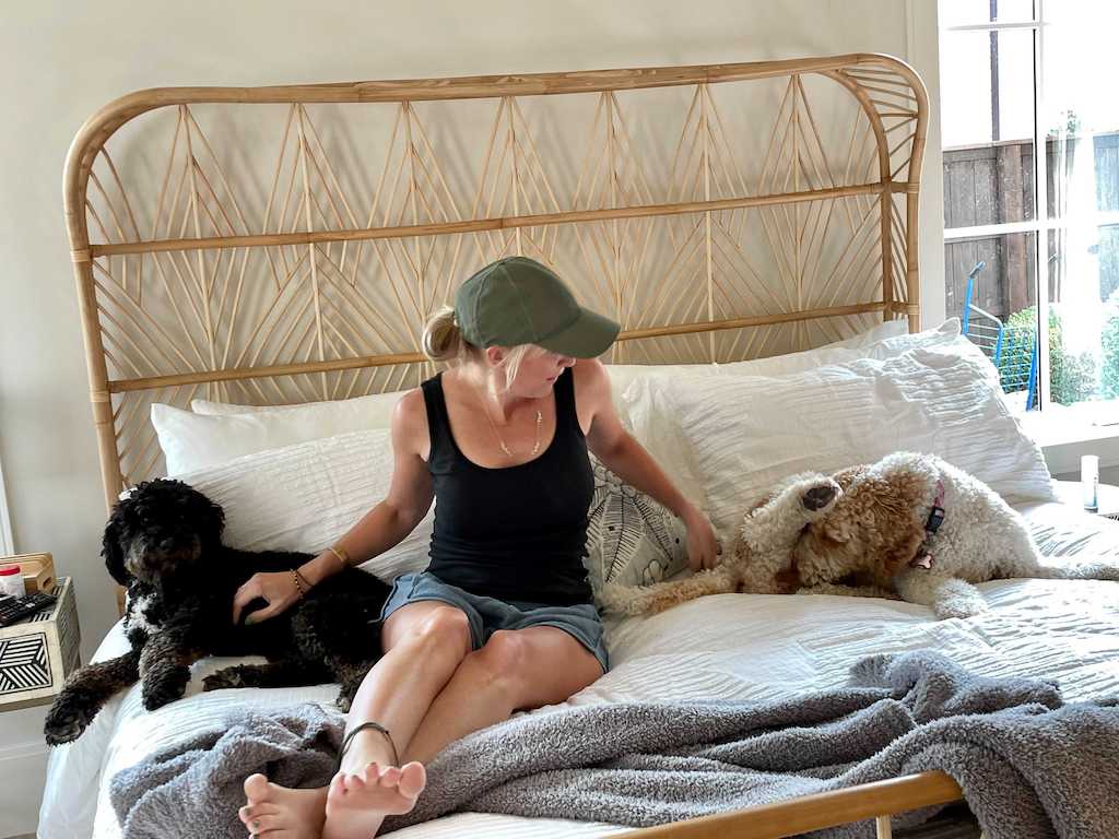 woman on rattan bed with dogs 