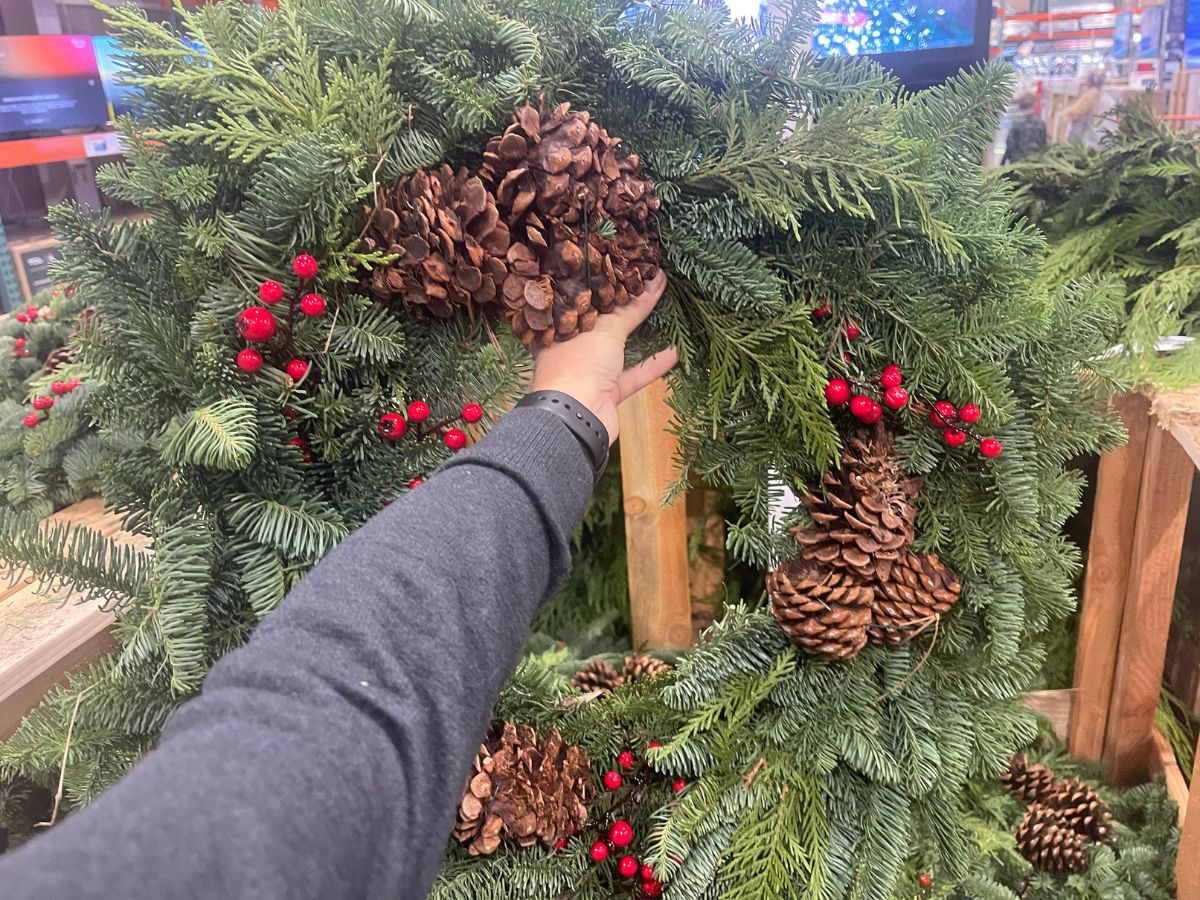 a womans hand displying a 28-inch wreath at costco