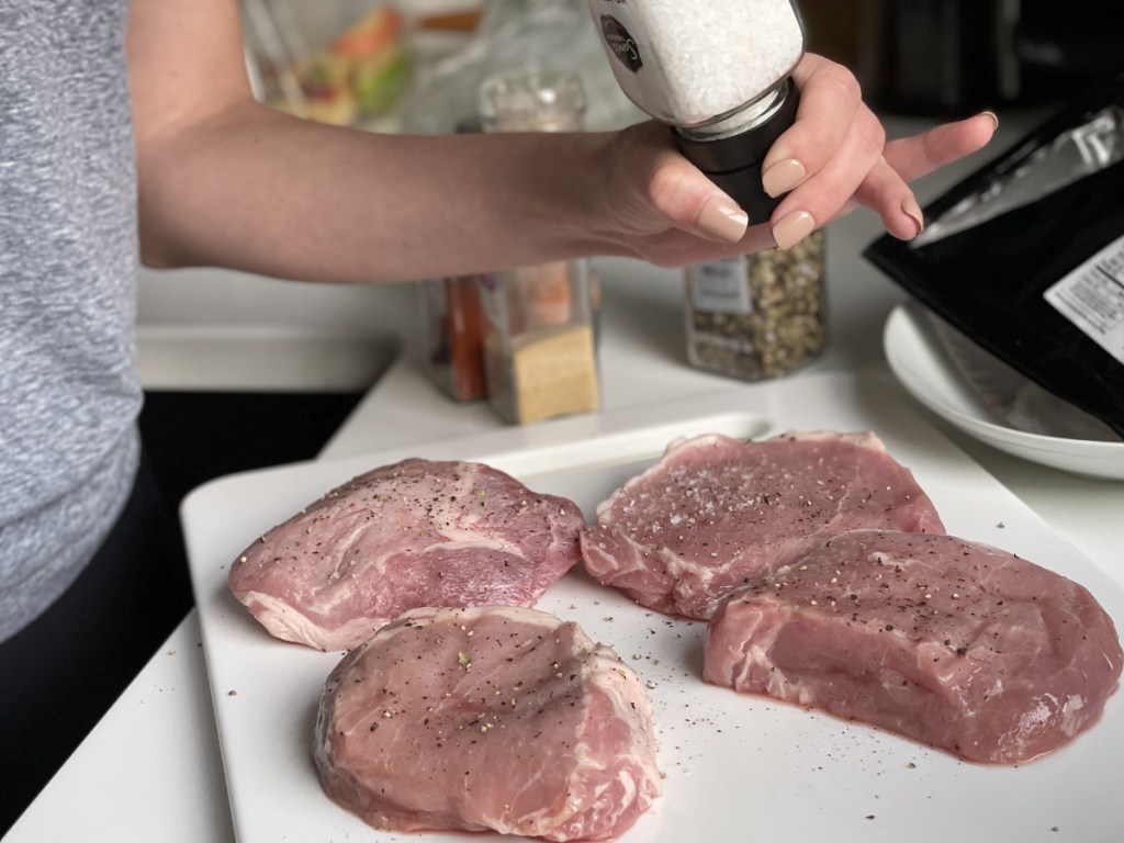A Woman seasoning pork chops