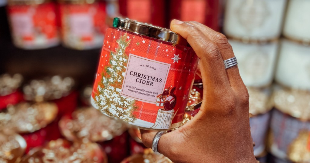 person holding up Bath Body Works Christmas Cider Candle in store