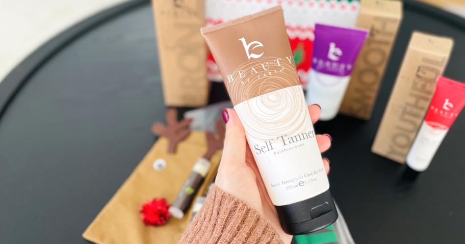 hand holding bottle of beauty by earth self tanner