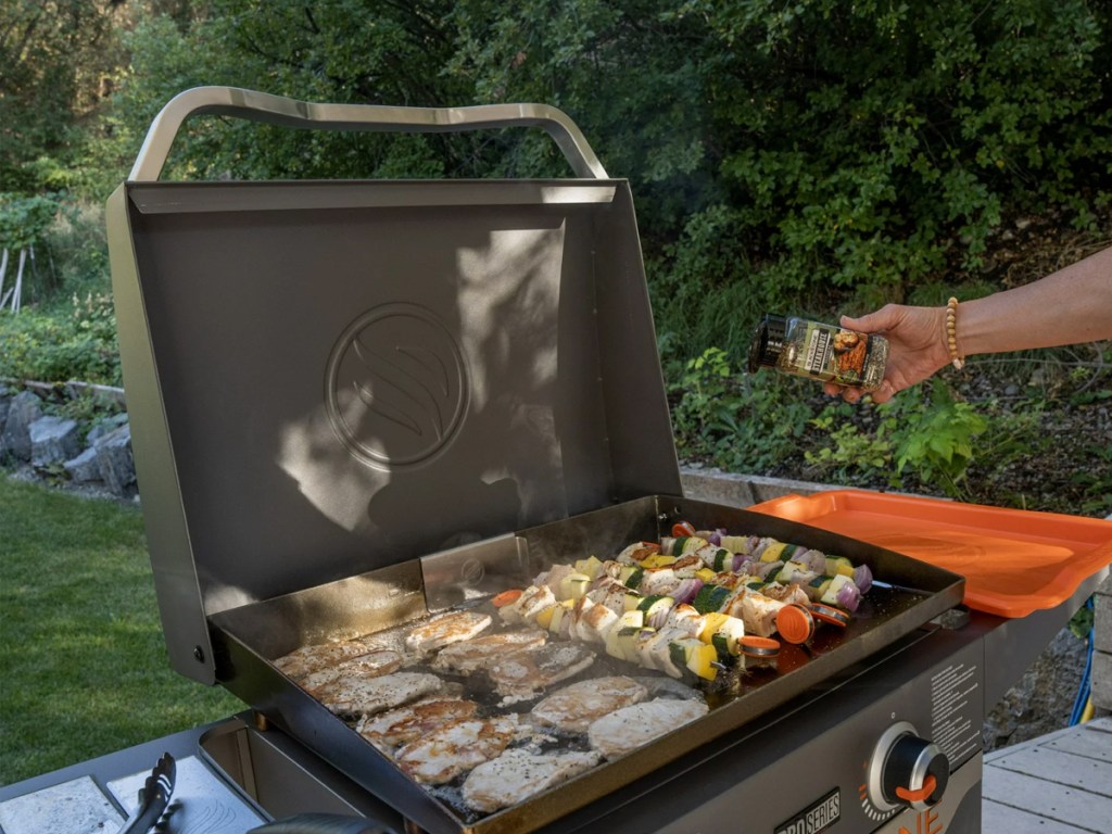 seasoning food cooking on an outdoor griddle