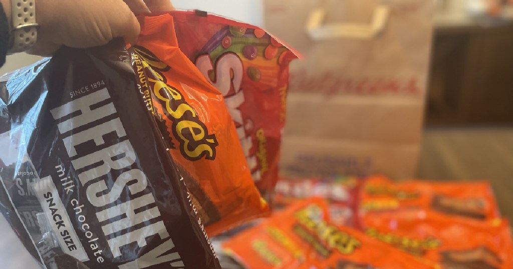 Hersheys Reeses Skittles hand holding candy bags Walgreens bag