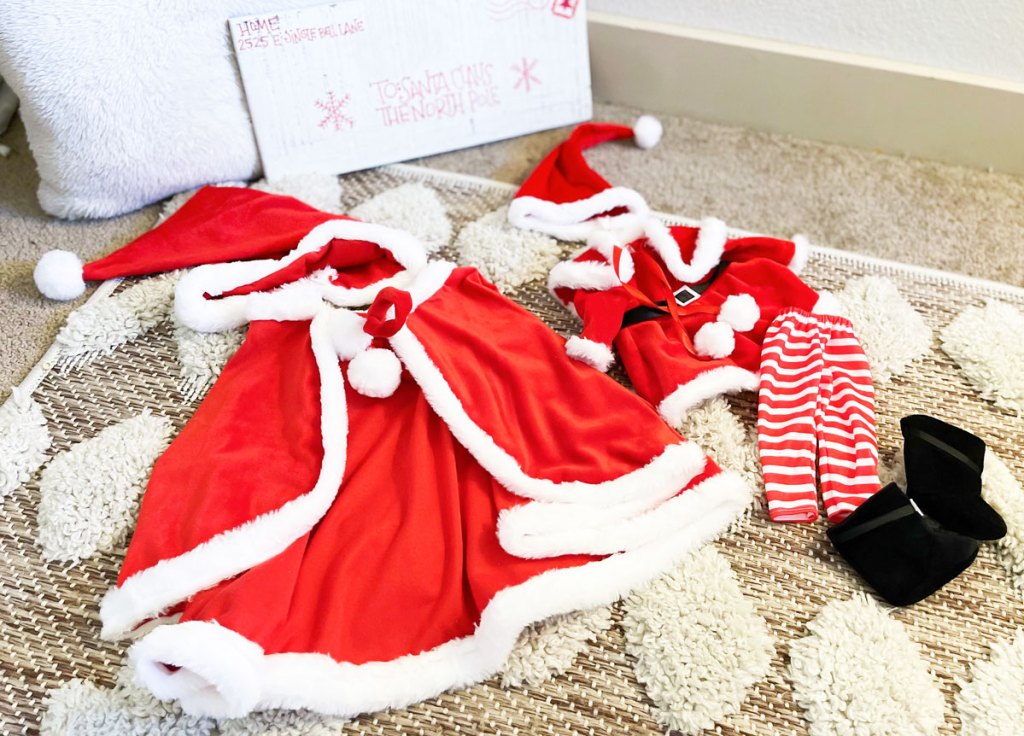 matching girl and doll santa outfits on floor