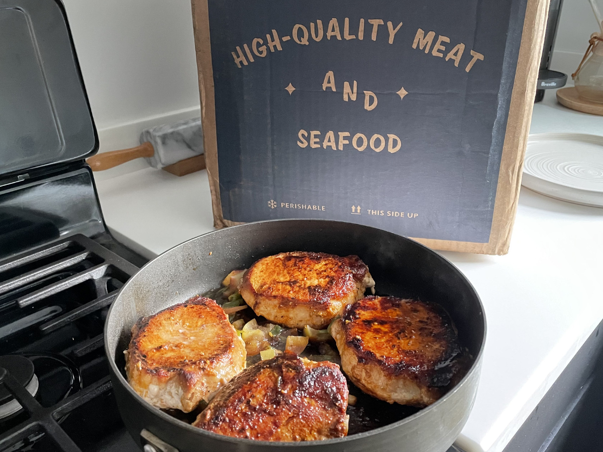 Cooked pork chops in pan with Good Chop box in background