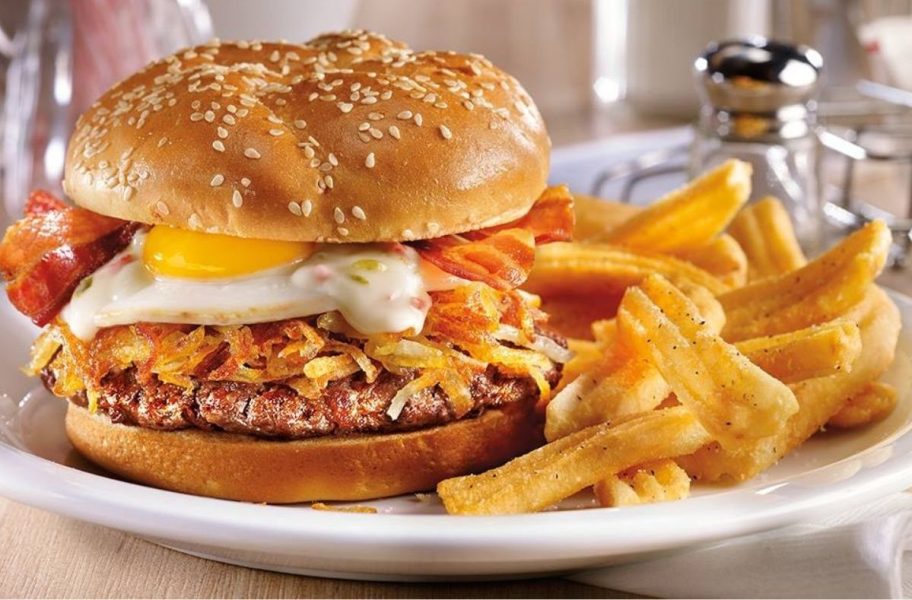 Denny's Burger with egg and hashbrowns on plate with fries