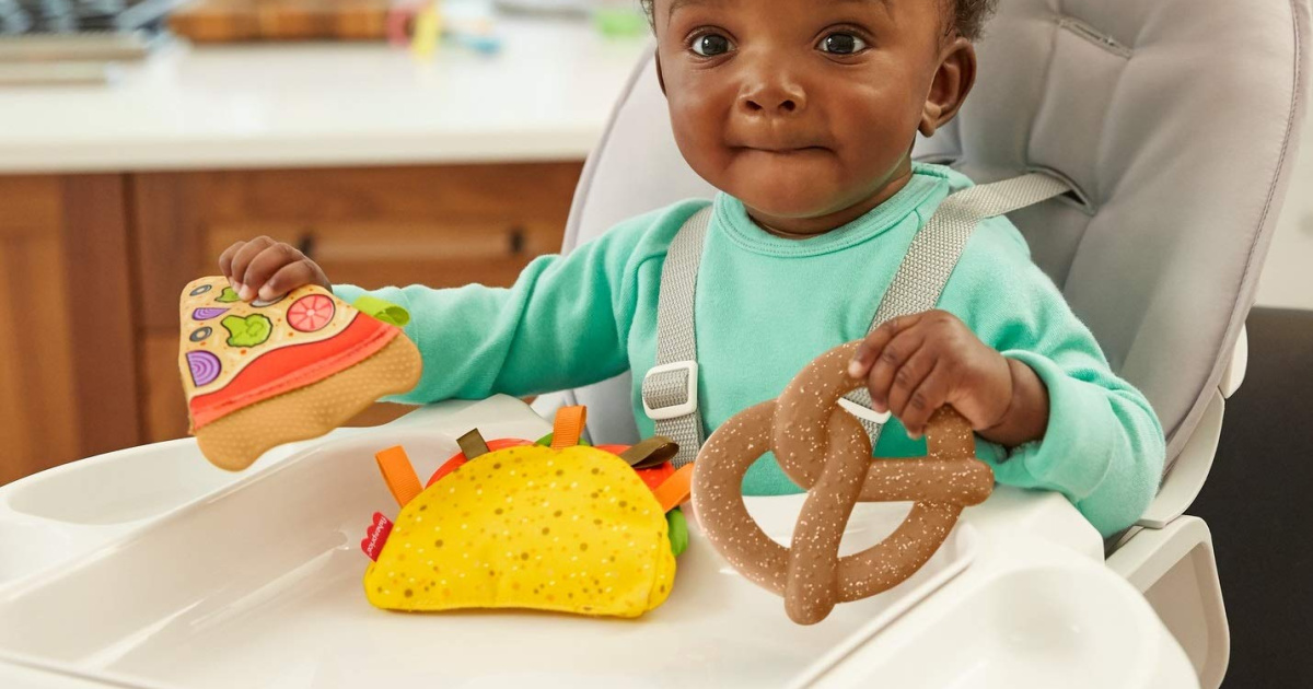 baby in high chair with food toys