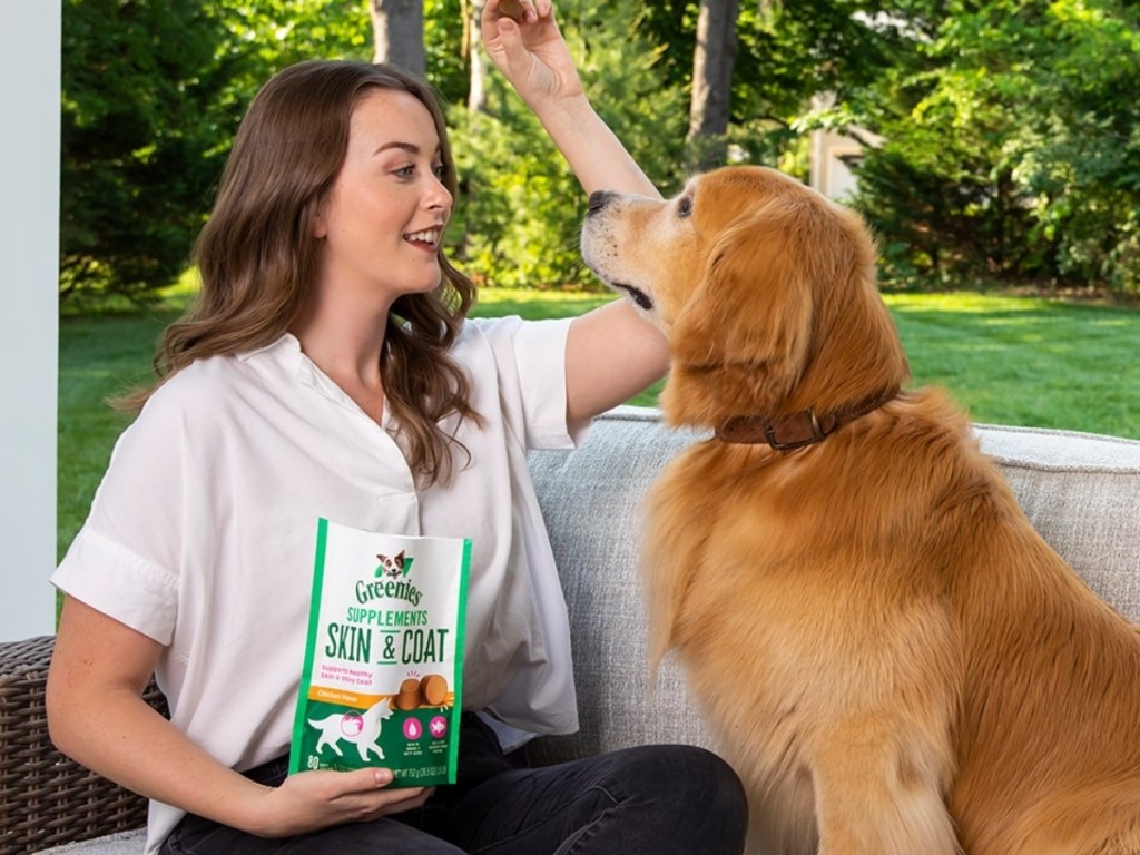 woman feeding dog greenies skin and coat supplement