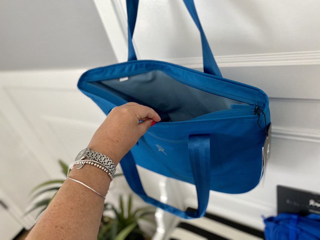 hand opening a Hydro Flask Cooler Tote