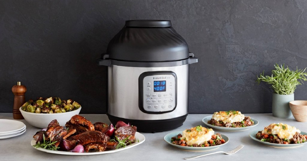 pressure cooker and air fryer combo appliance on counter with plates of food