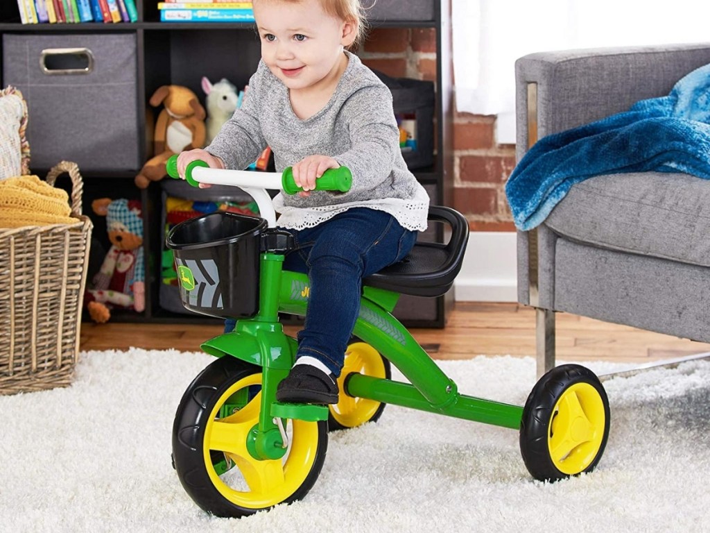 young girl riding john deere pedal tricycle