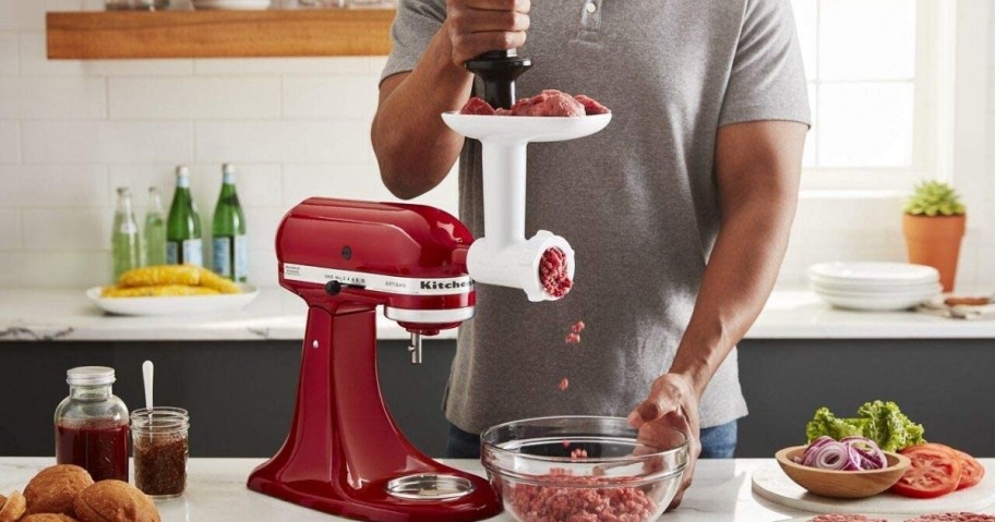 man using kitchenaid grinder accessory to ground meat into bowl in kitchen