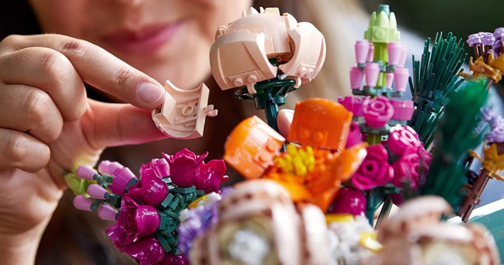 woman making flowers from building toy pieces