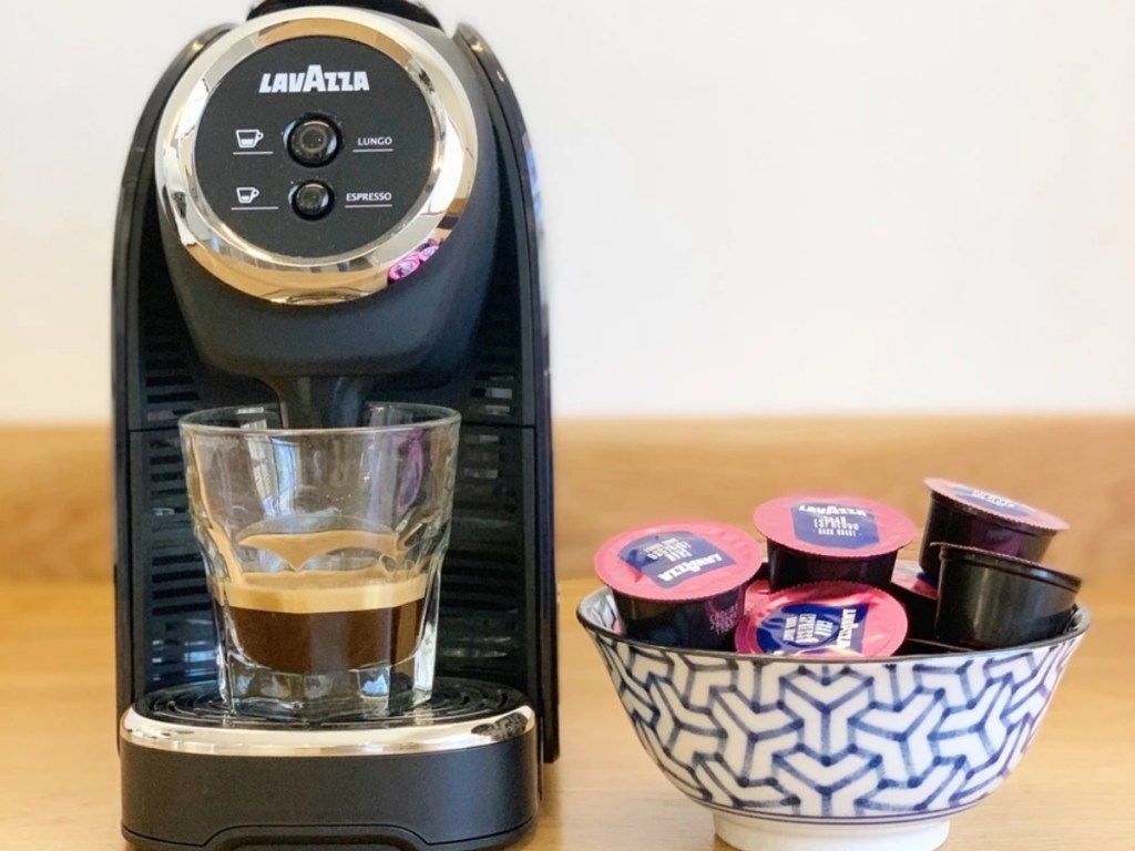 lavazza blue classy mini espresso machine on table with capsules