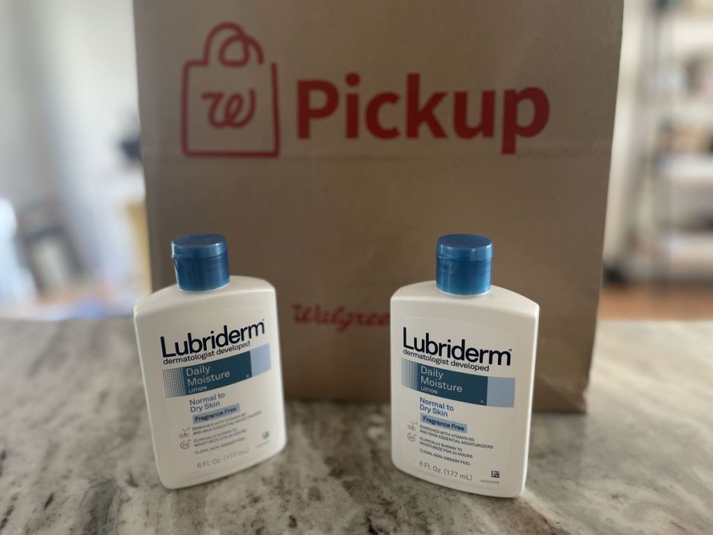 two Lubriderm lotions by a Walgreens bag