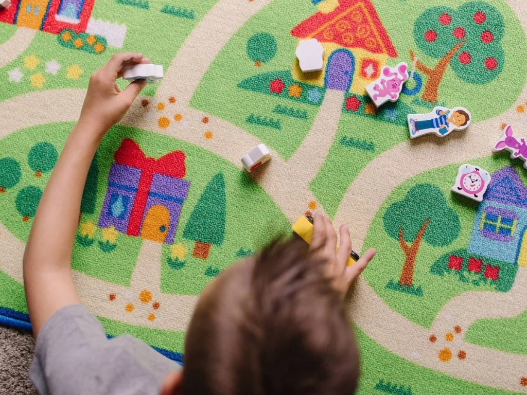 boy playing with melissa & doug blues clues activity rug